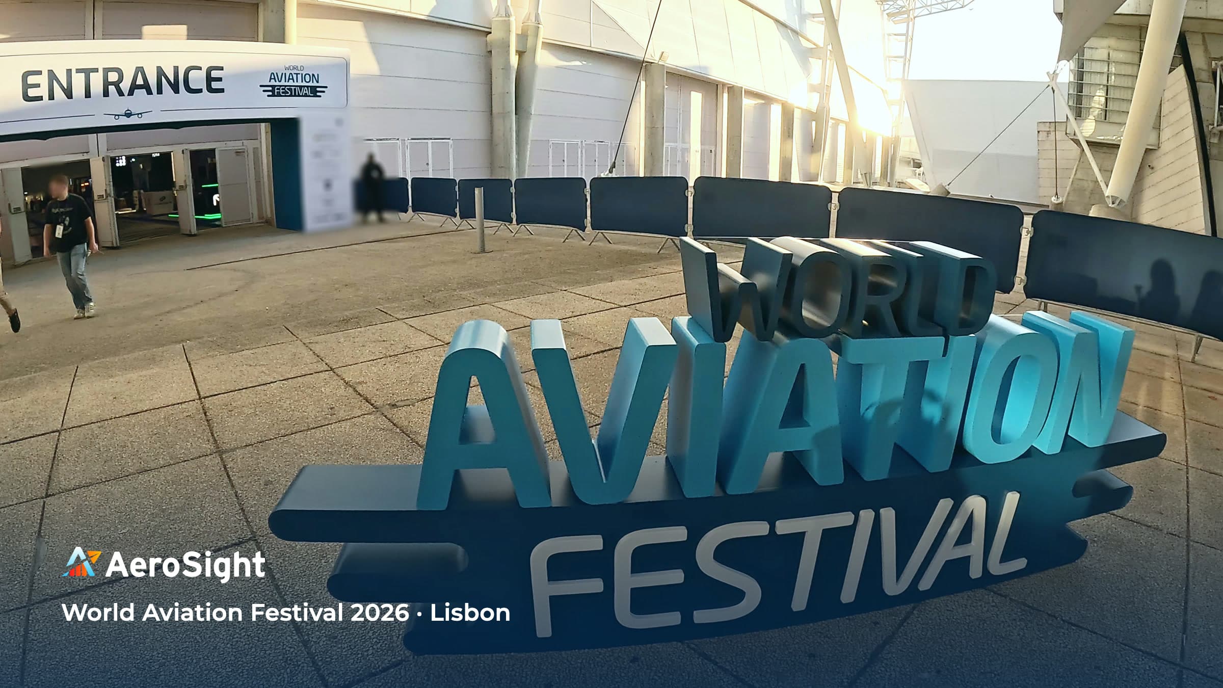 The World Aviation Festival sign and the entrance to FIL Lisbon in the early-morning sun